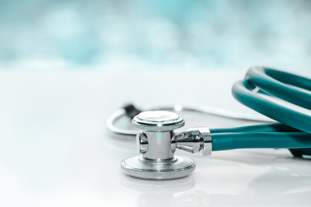 Stethoscope or phonendoscope on a doctor's white desk on cloudy morning. Treatment of cold or flu.