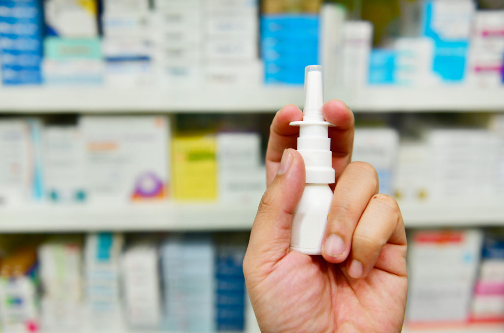 Close up shot pharmacist holding nasal spray medicine at the drugstore